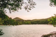 日落时分，宁静的湖面被郁郁葱葱的青山和树木环绕