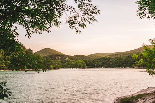 日落时分，宁静的湖面被郁郁葱葱的青山和树木环绕