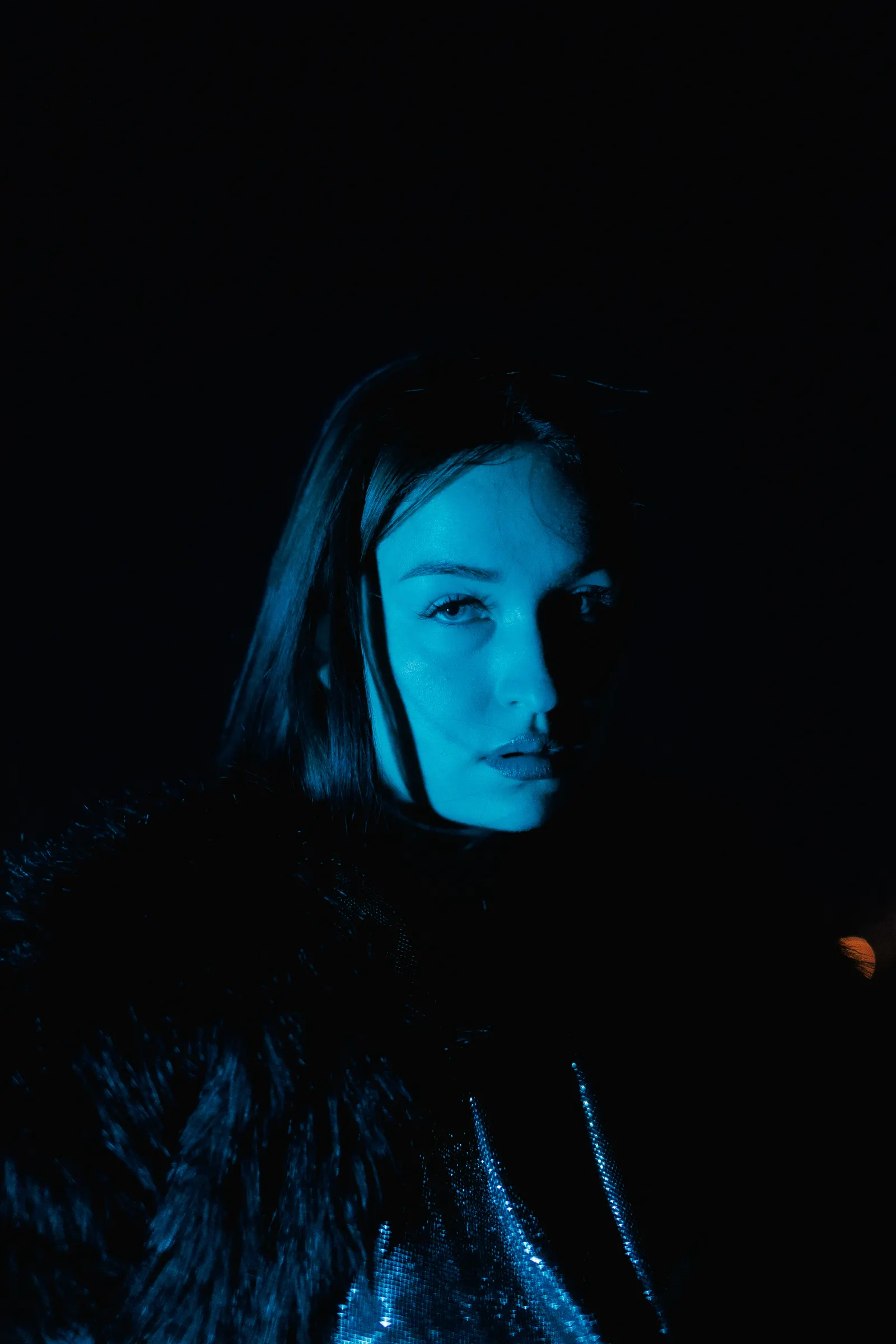 Woman photographed in deep blue light, Atelier Nocturne