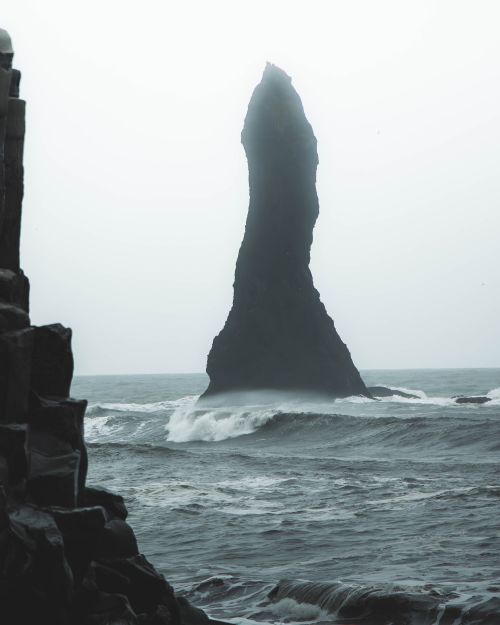 Free Moody ocean scene with towering rock formation at sea's edge. Stock Photo