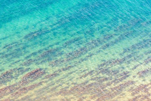 Free Crystal clear turquoise waters viewed from above, capturing sea textures. Stock Photo