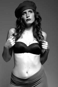 Artistic black and white portrait of a woman wearing a beret and top.