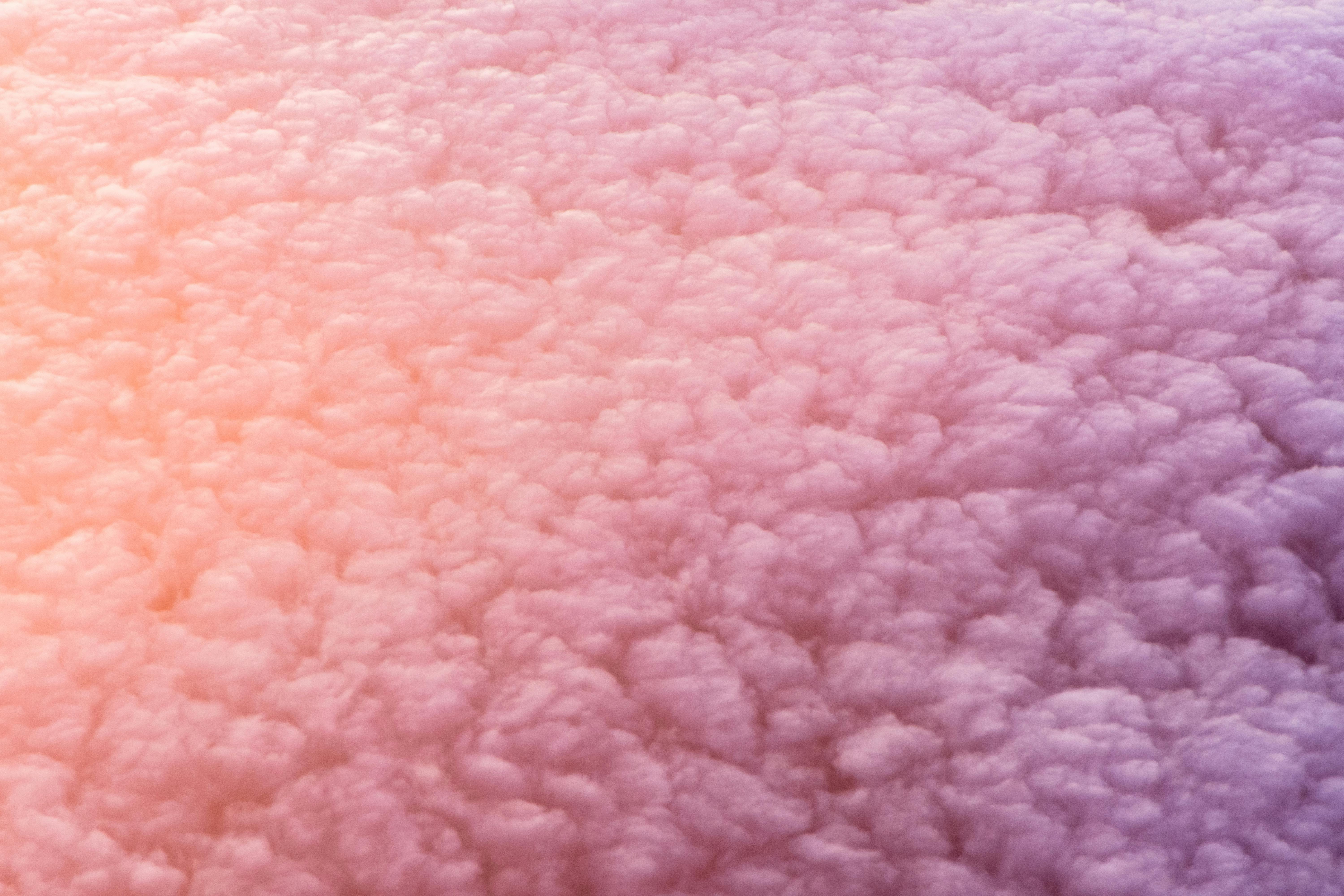 一幅柔软、柔和的粉红色云彩抽象视图，类似纹理织物或羊毛
