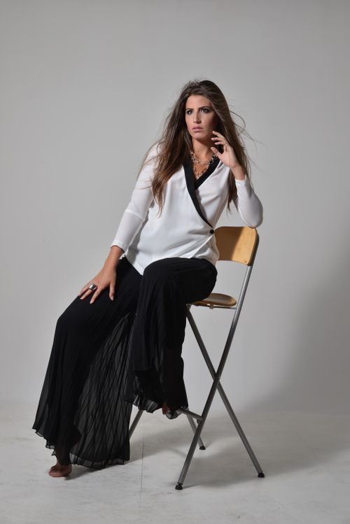 Free Elegant young woman posing in a studio setting wearing fashionable attire. Stock Photo