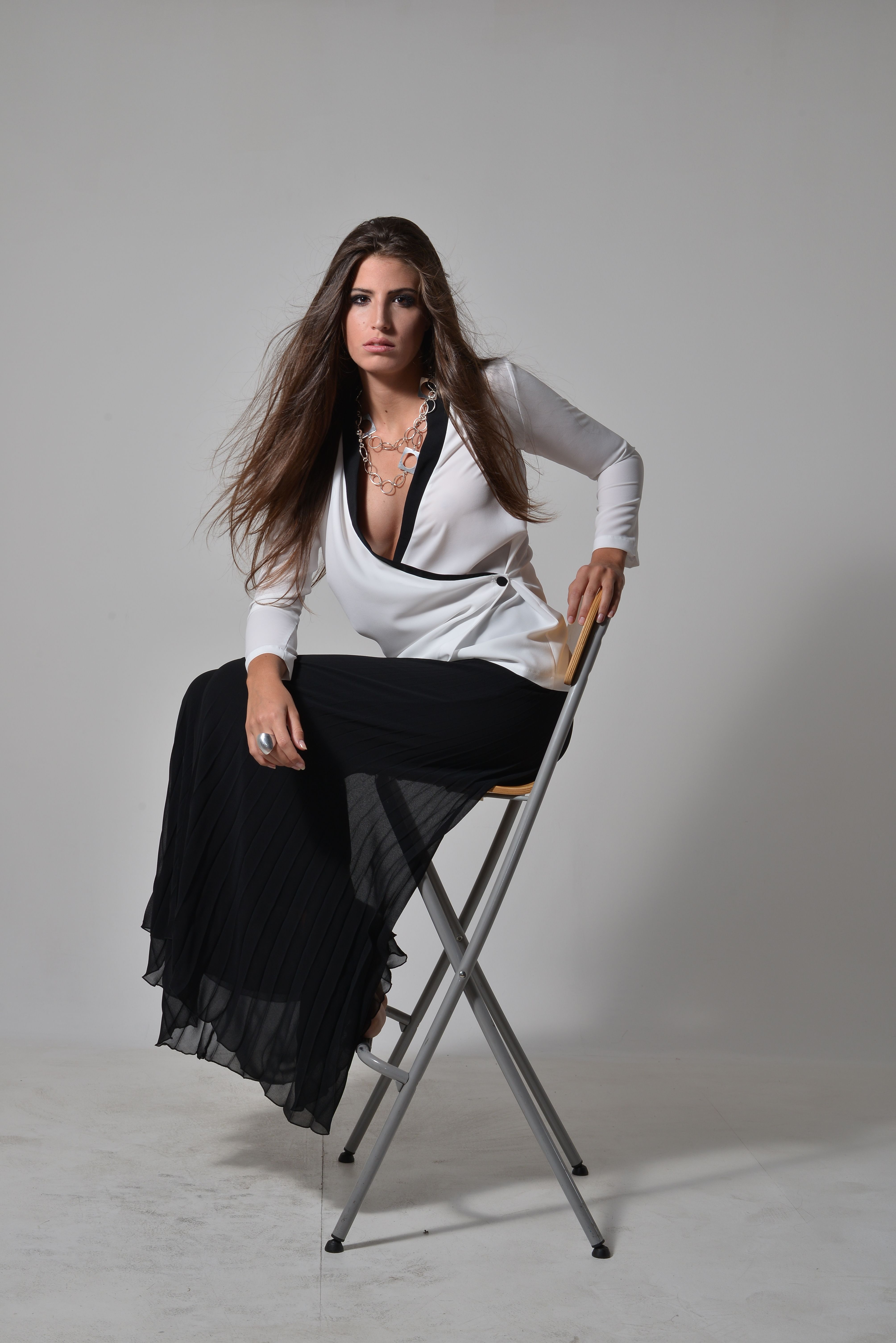 Elegant Woman Seated on Chair in Studio · Free Stock Photo