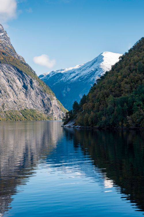 Free Scenic vista of a Norwegian fjord with clear blue skies and majestic mountains. Stock Photo