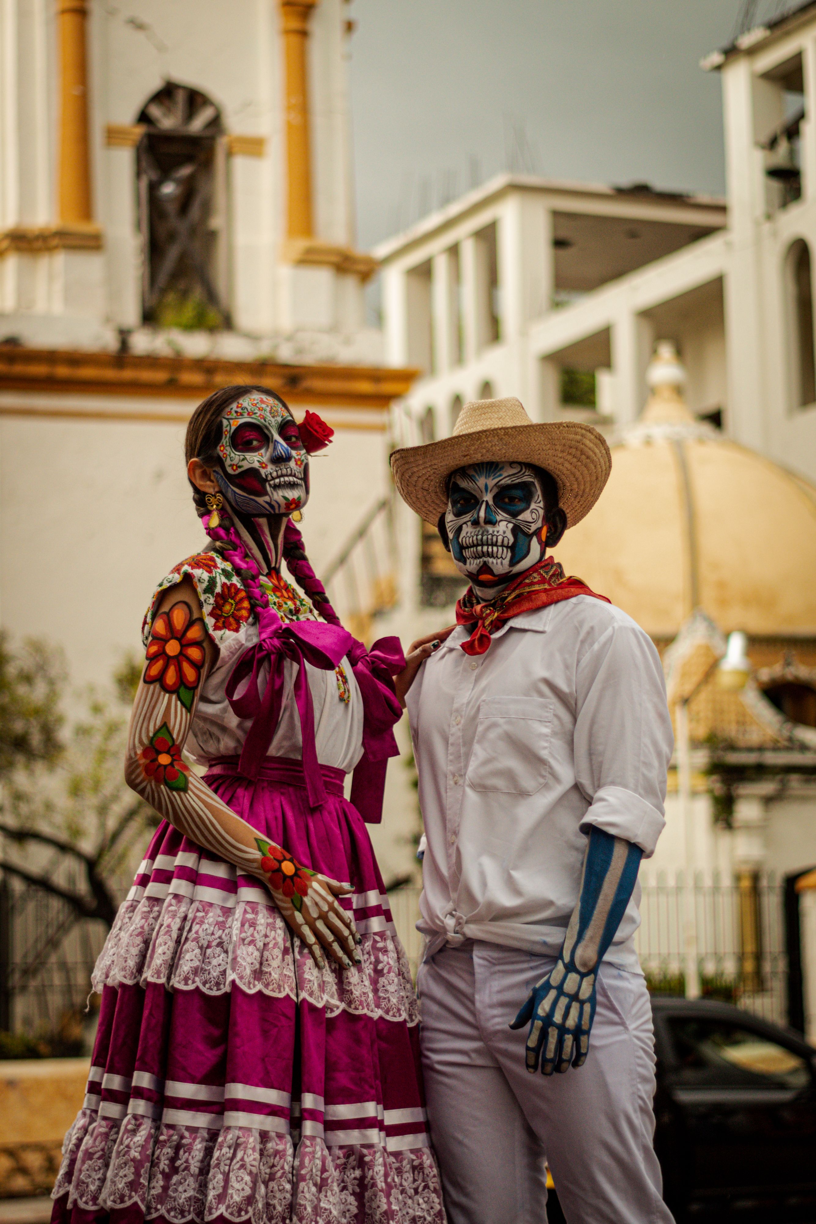 Two people in traditional Catrina and Catrin costumes during Day of the Dead celebrations in Oaxaca, Mexico