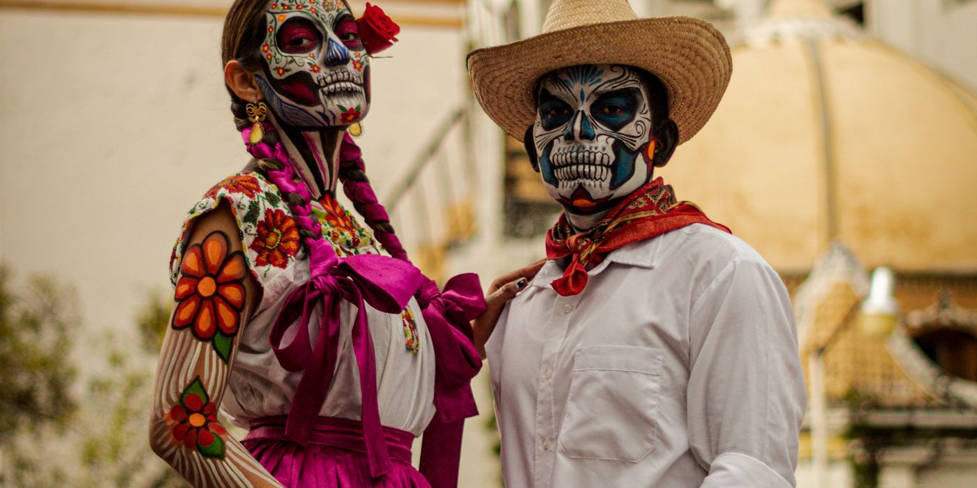Two people in traditional Catrina and Catrin costumes during Day of the Dead celebrations in Oaxaca, Mexico