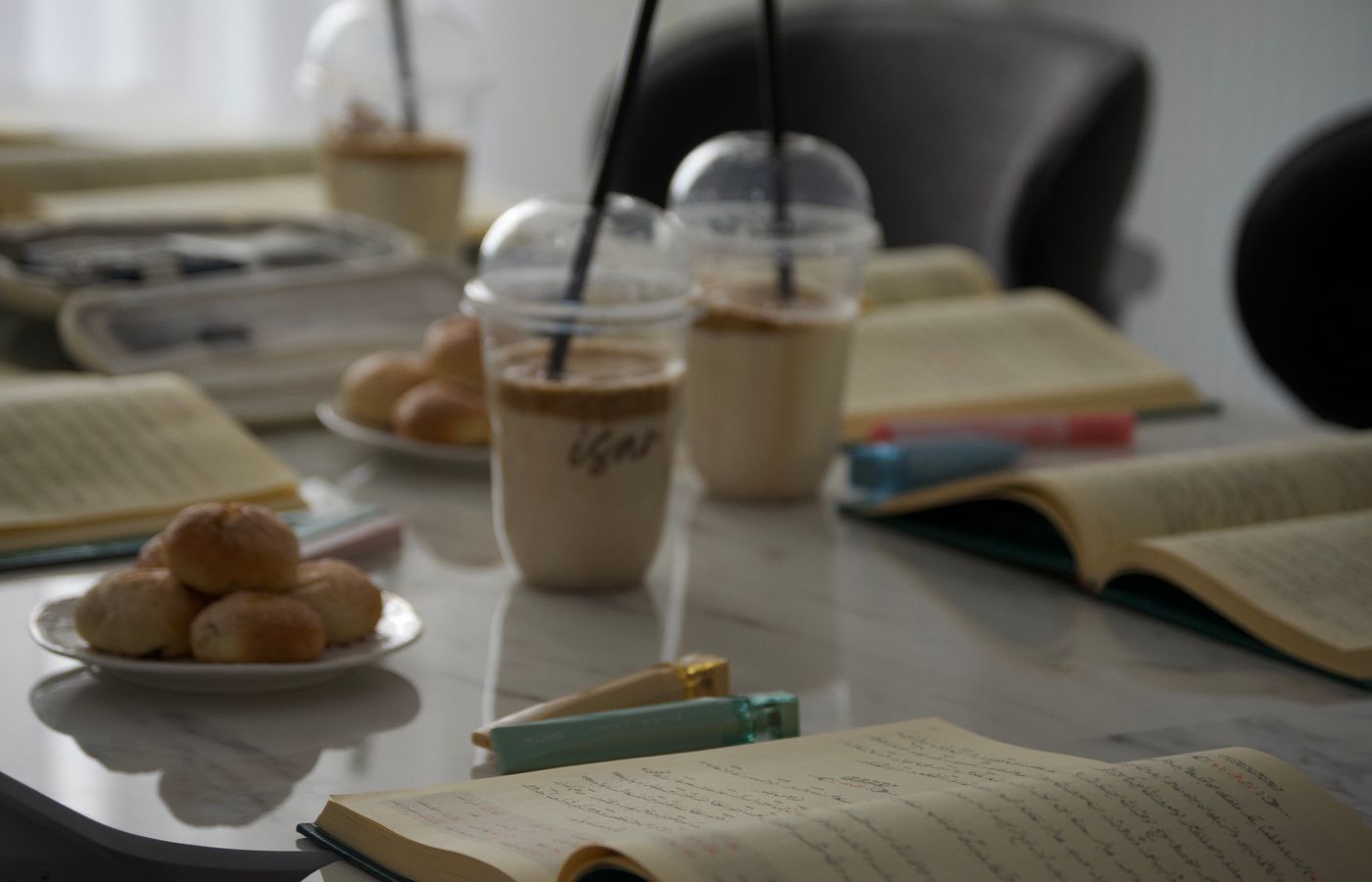 Quiet study session with iced coffee, notebooks, and snacks on a desk.
