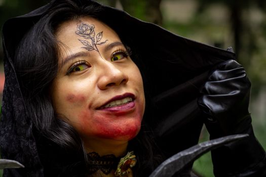 Close-up of a woman in vampire cosplay, featuring a rose tattoo and yellow contact lenses, outdoors.