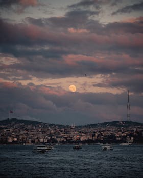 Captivating view of a moonlit cityscape over İstanbul's skyline with dramatic clouds.