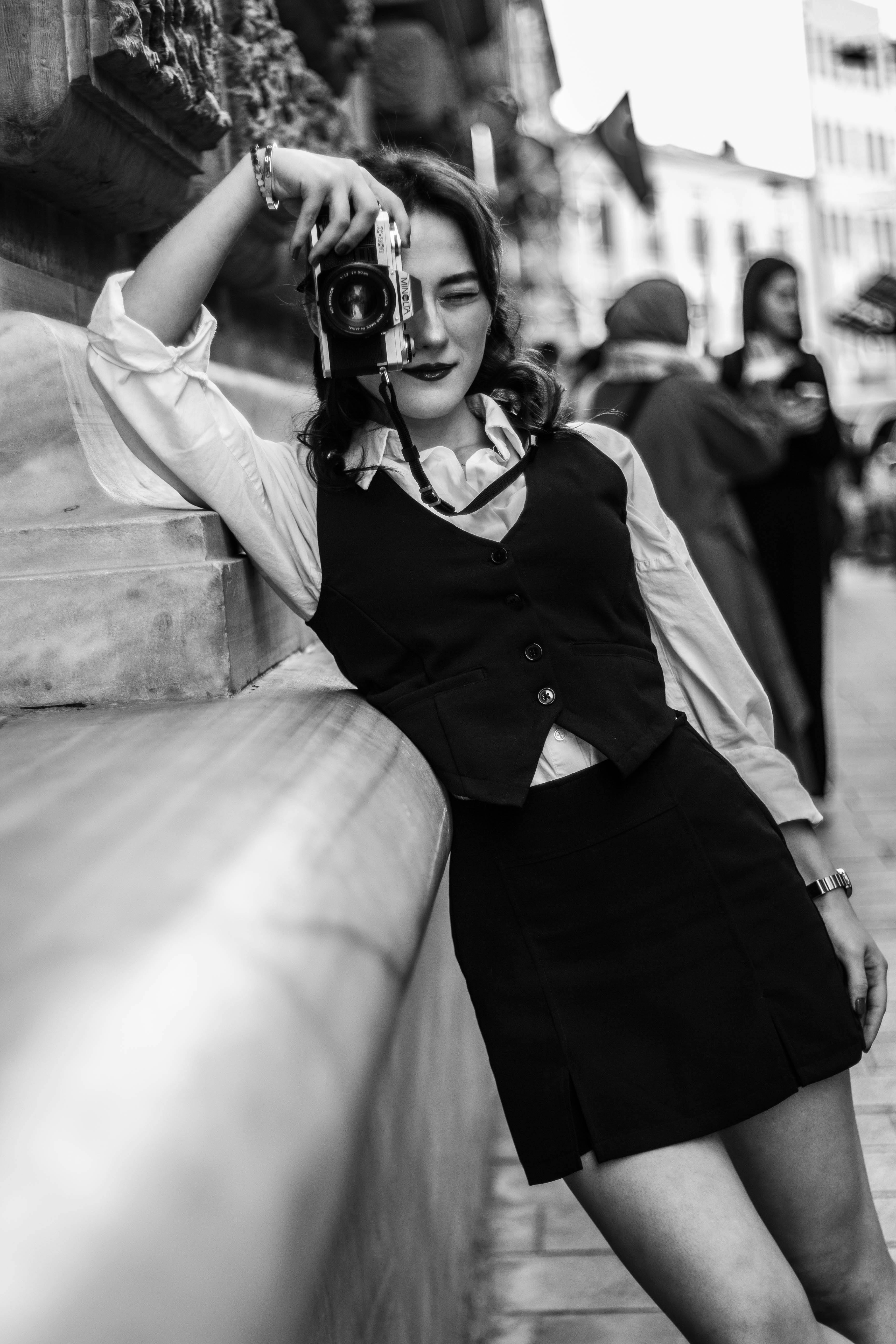 Stylish photographer in İstanbul capturing urban charm with a classic camera.