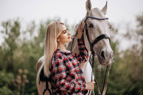 Free Woman bonding with a horse in a peaceful outdoor environment. Stock Photo