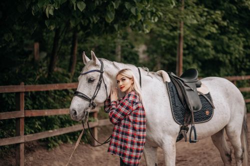 Free Young woman embracing a white horse outdoors in a rustic setting. Stock Photo