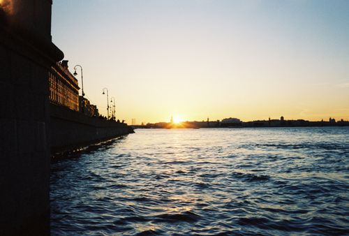 Free Silhouette of city buildings at sunset with waterfront view, creating a serene and picturesque scene. Stock Photo