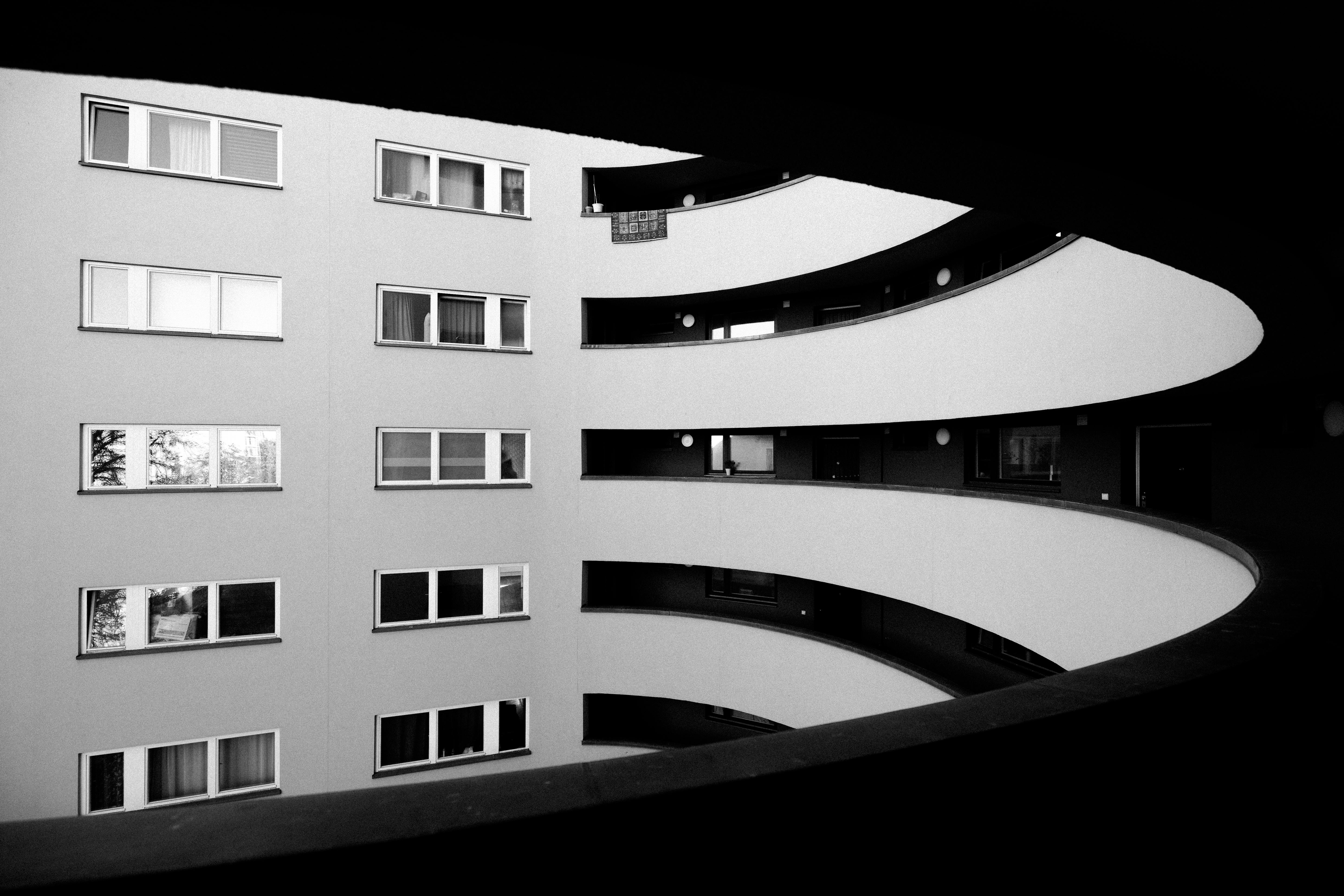 A striking black and white photo showcasing the curved geometry of a Berlin apartment building.
