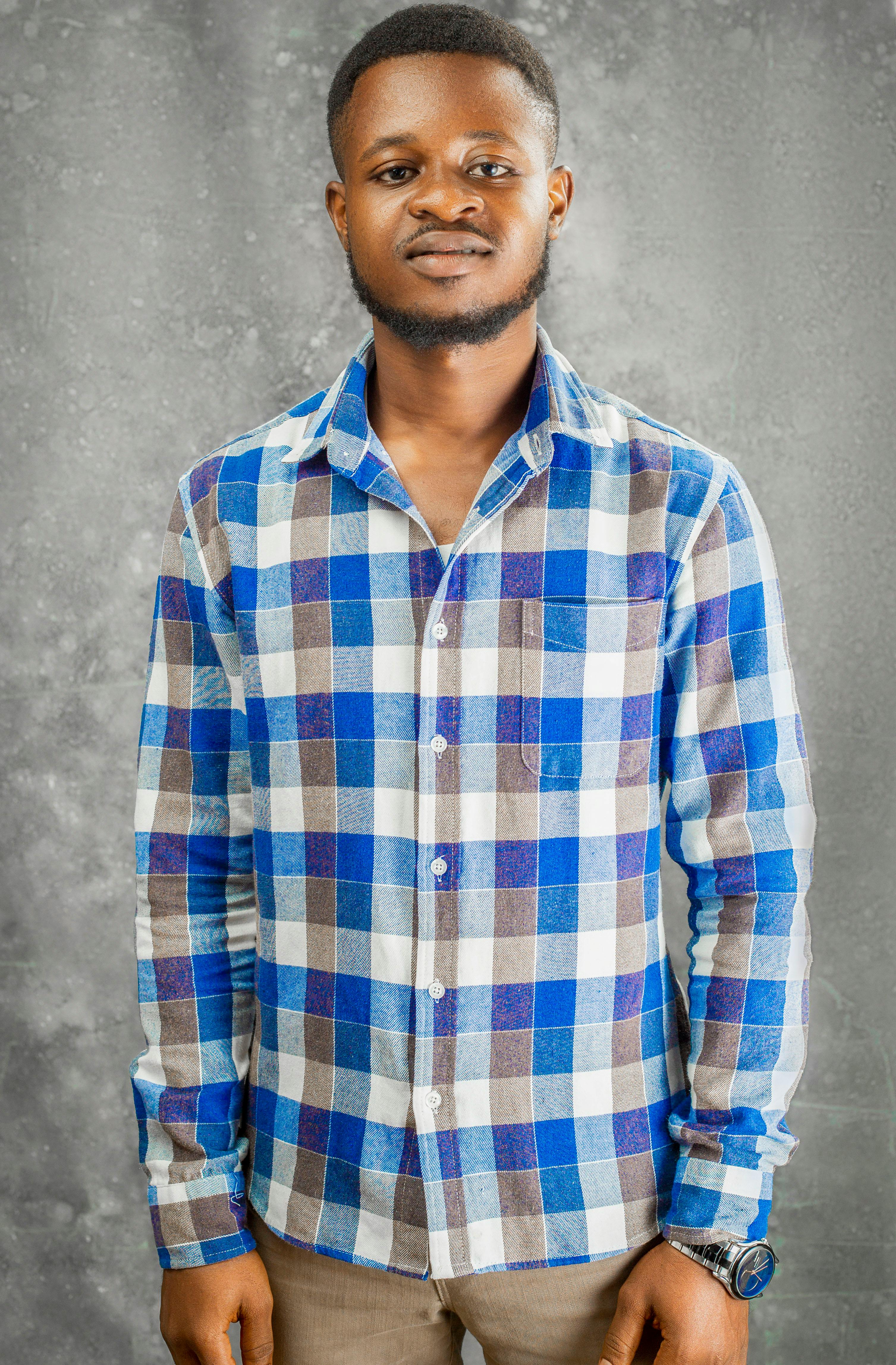 Casual portrait of a man wearing a blue and brown checked shirt.
