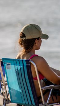 Woman enjoying a sunny day on a beach chair at Tourinhos, Brazil.