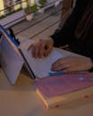 Woman Typing on Laptop with Books on Table
