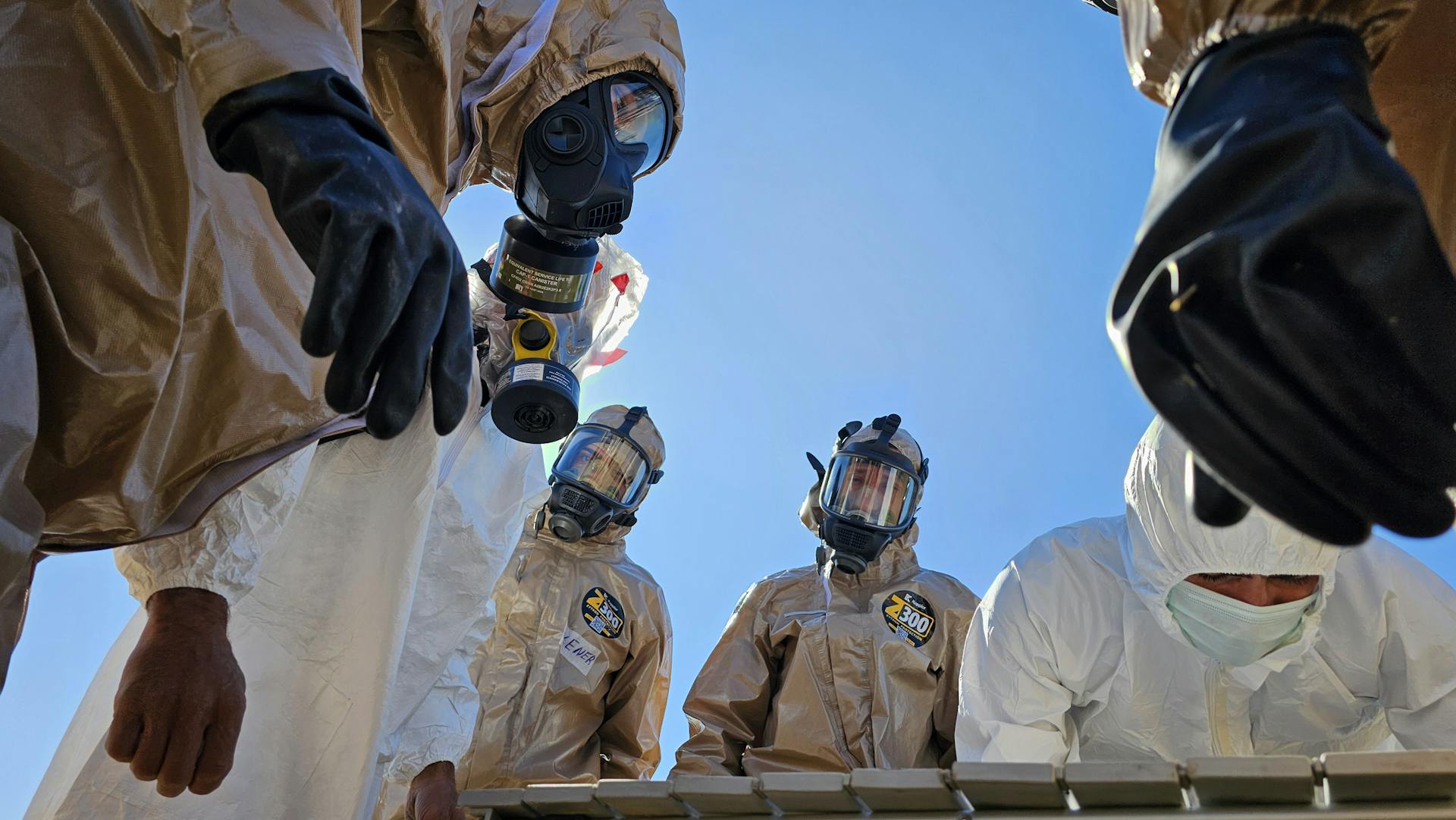 Team in Hazard Suits Inspect Surroundings