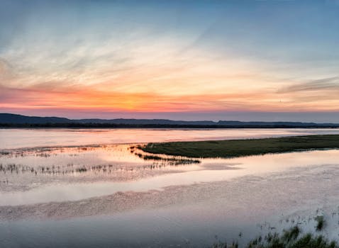 Captivating sunrise over the Mississippi River's tranquil waters in Minnesota, showcasing vibrant colors and calm reflections.