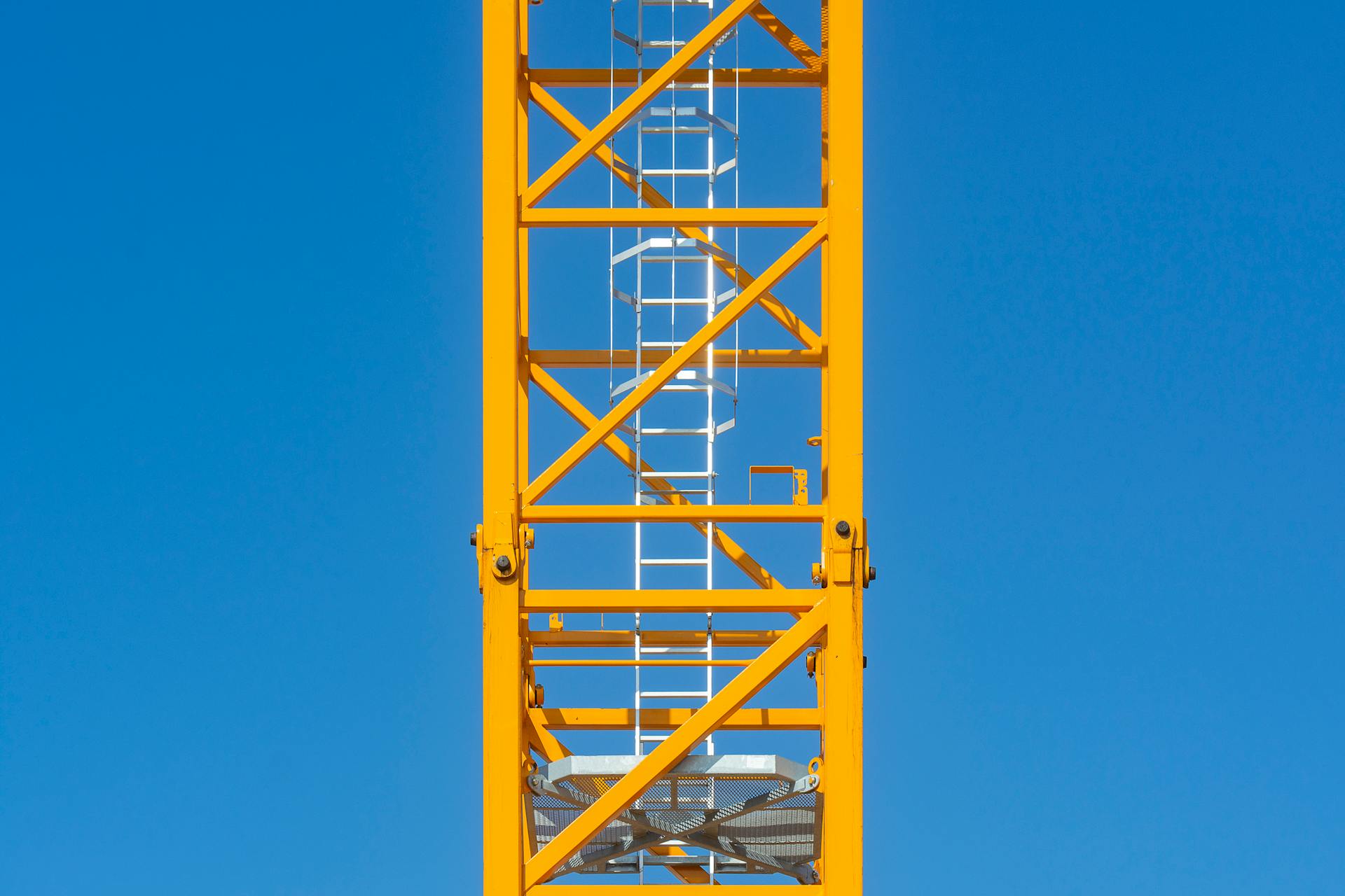 Yellow Construction Crane Tower Against Blue Sky