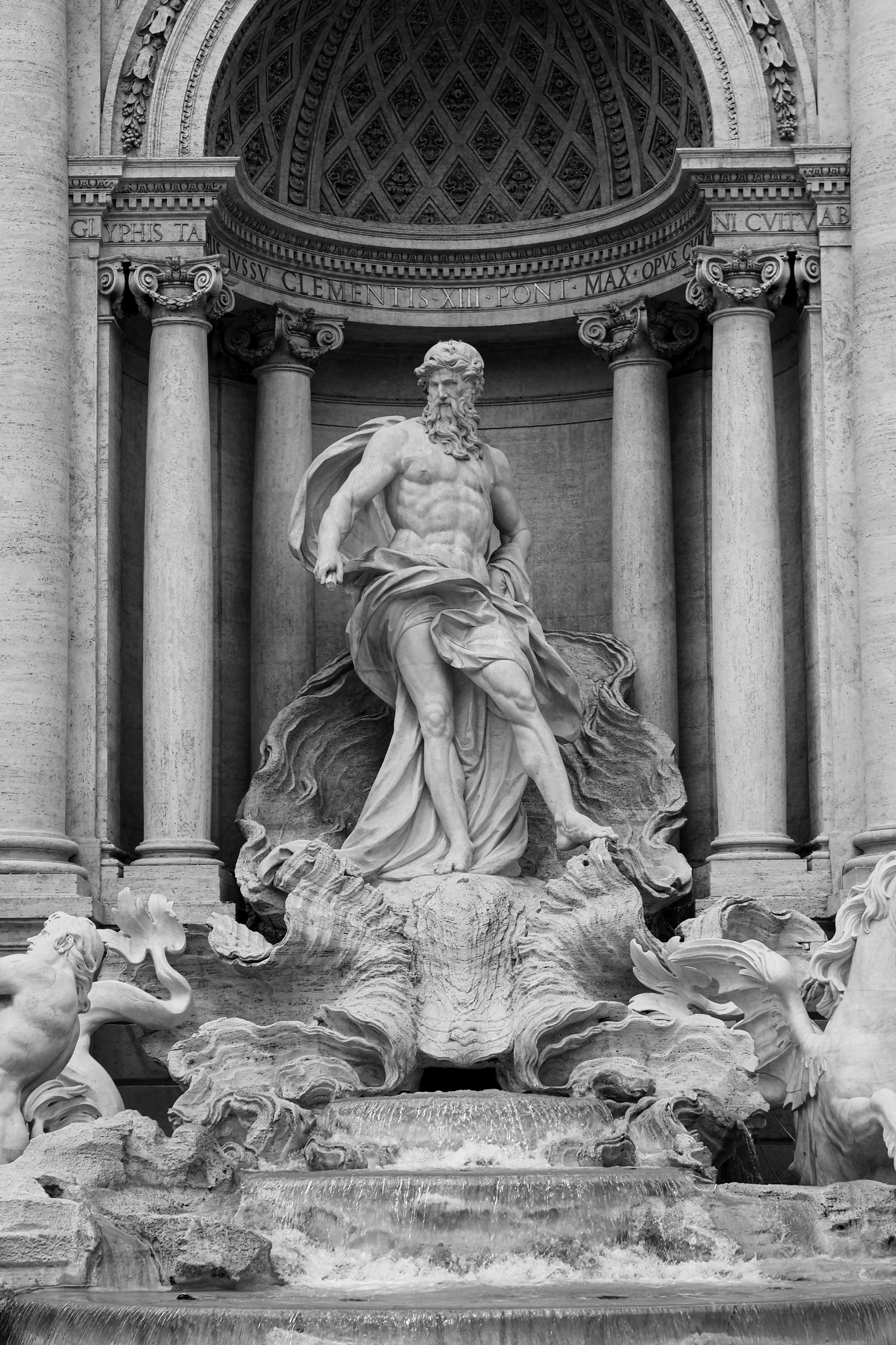 Detailed grayscale photo of the famous Neptune statue at Trevi Fountain in Rome, Italy.