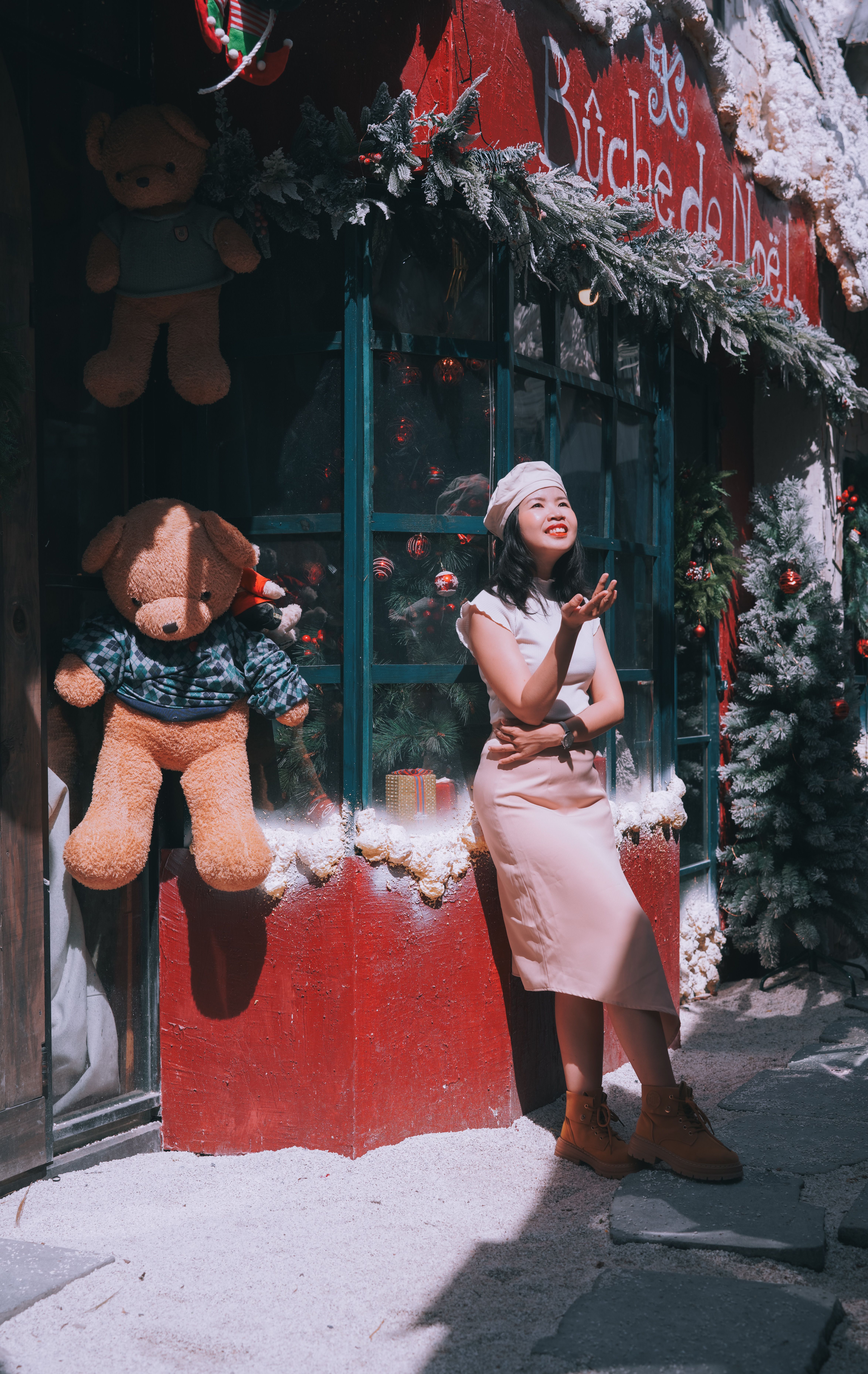 Woman enjoys sunny day outside decorated store in Biên Hòa, Vietnam.