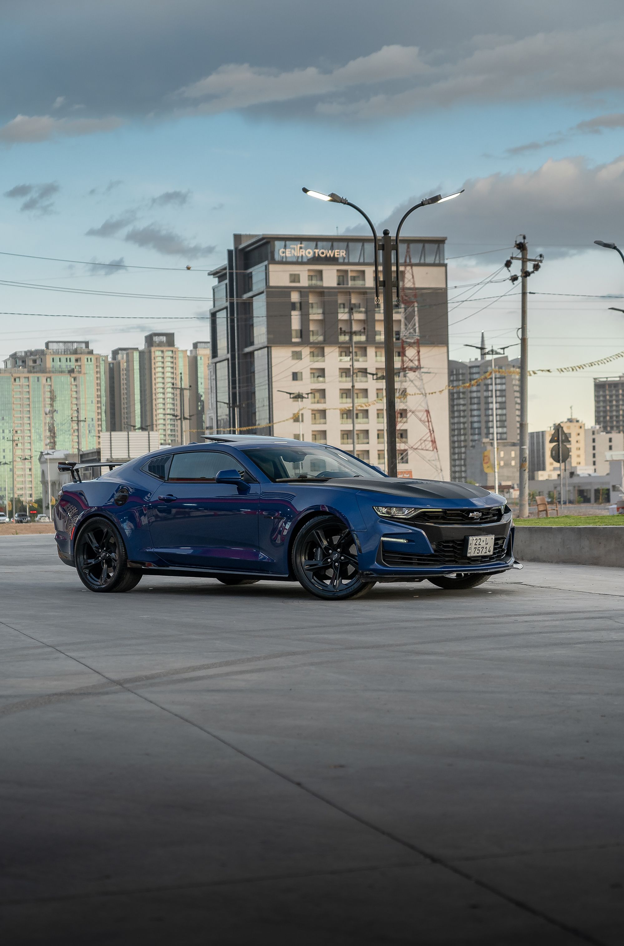 Modern Camaro ZL1 clearly badged and identifiable, high resolution, clean editorial composition against urban backdrop.