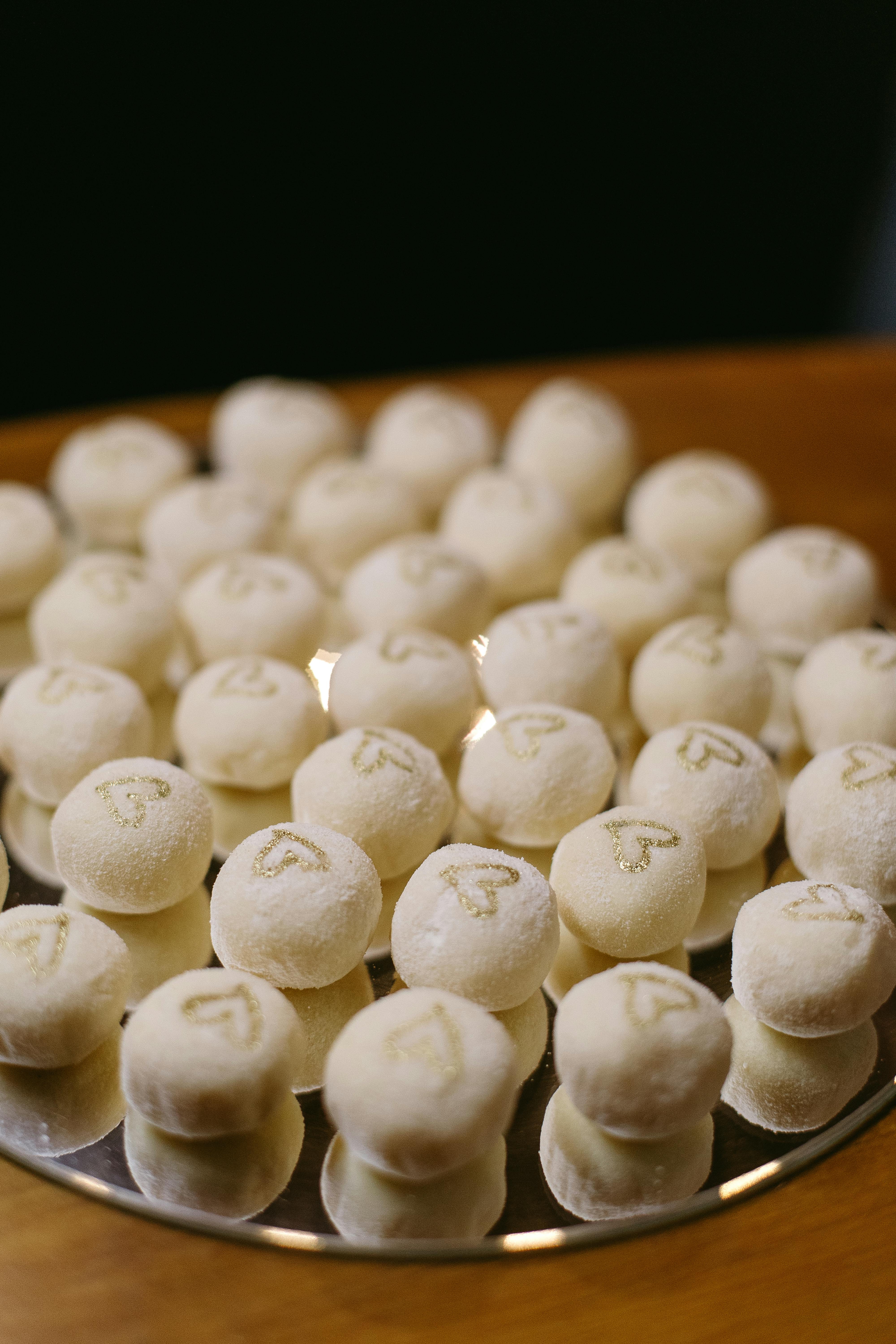 Delicious white sugar-coated balls with heart designs, perfect for special occasions.