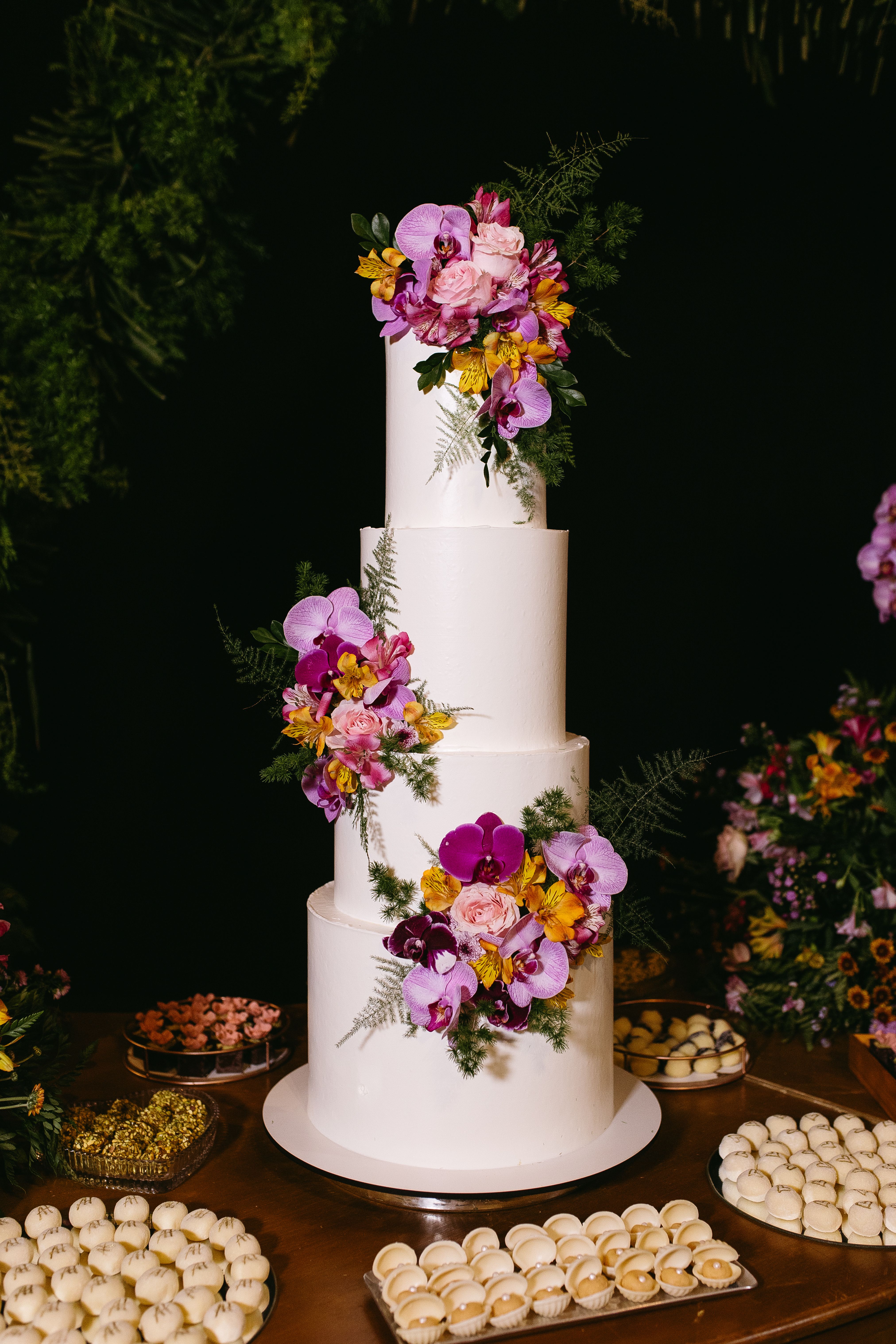 A three-tier wedding cake decorated with fresh flowers