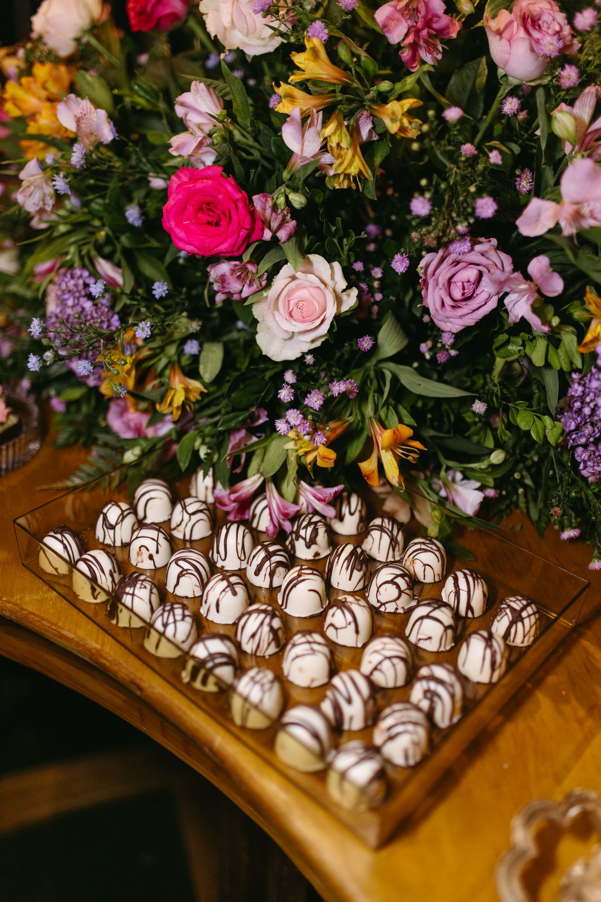 Red roses and assorted chocolates arranged together.