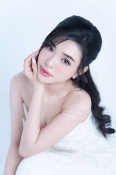 Elegant portrait of a woman in a white dress showcasing beauty and grace.