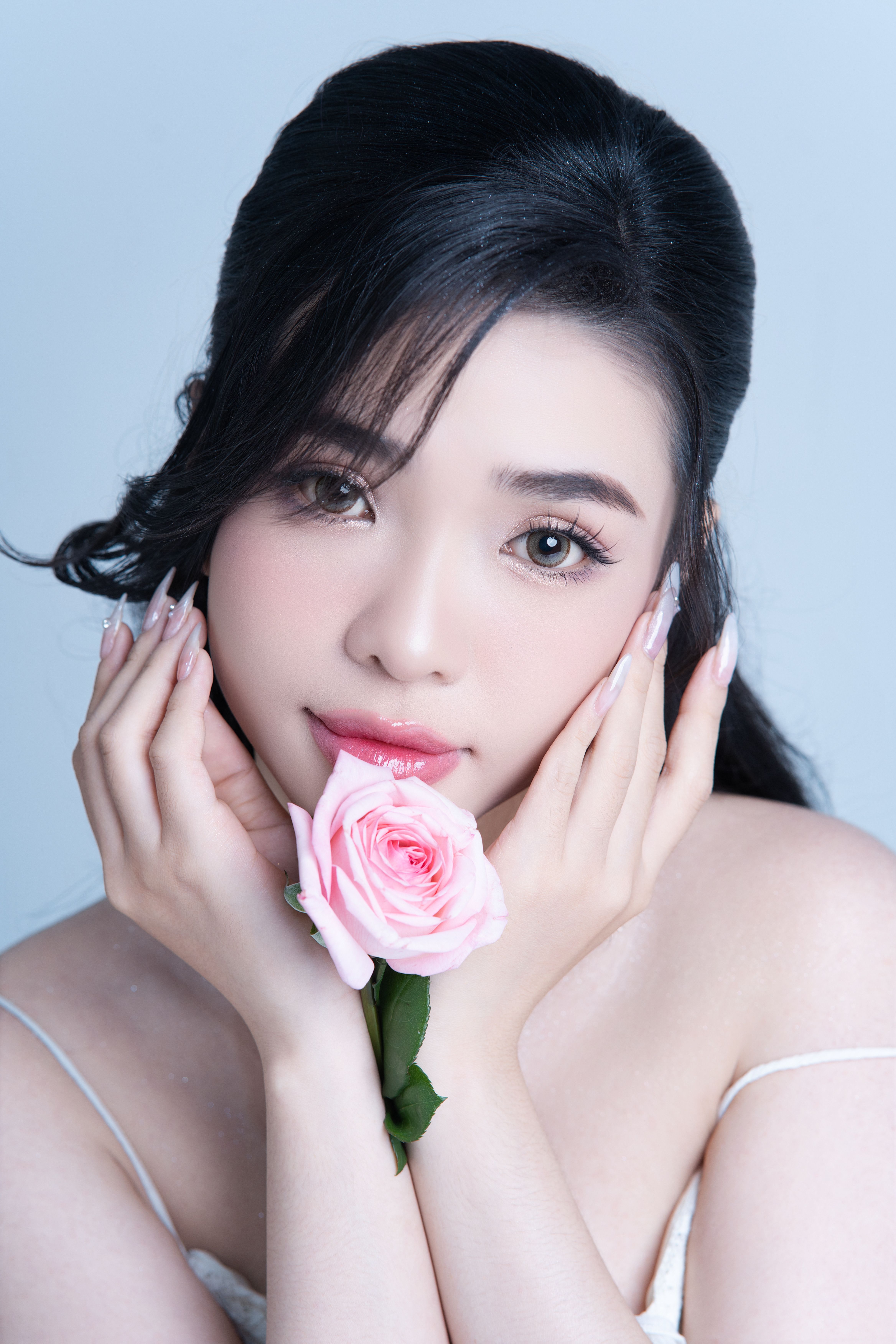 Close-up portrait of a woman with a rose, conveying elegance and beauty.