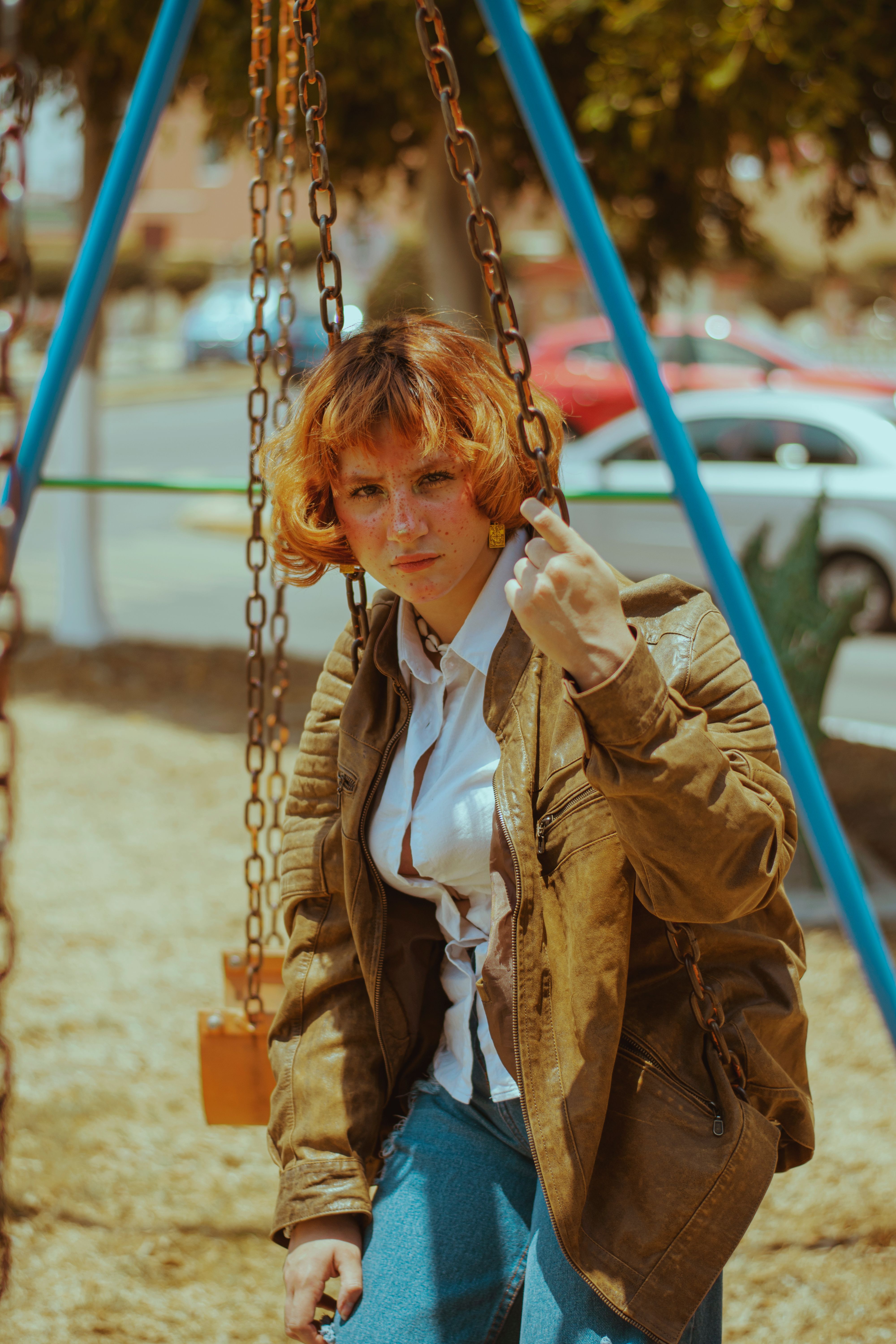 Young Woman on Swing in Urban Park Setting · Free Stock Photo