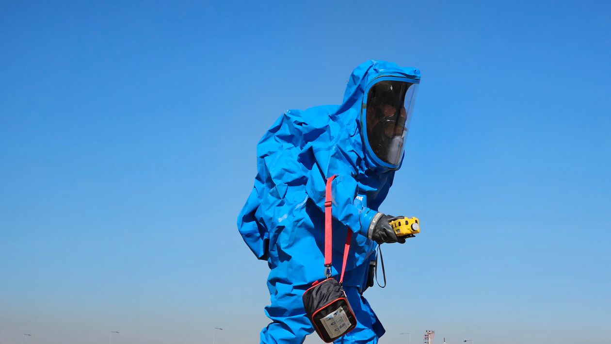 Technician in full protective suit conducting an outdoor asbestos inspection