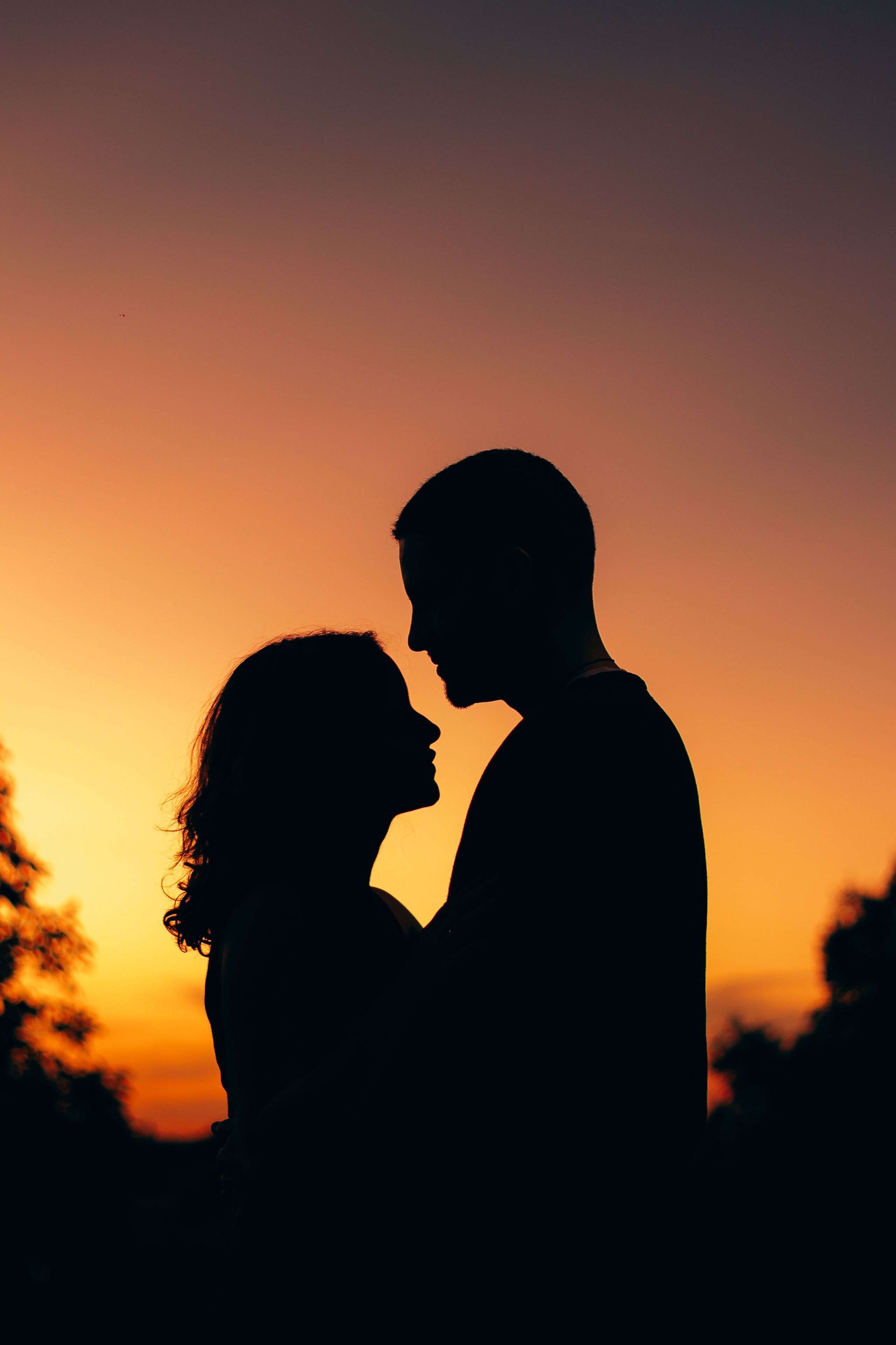 Silhouette of a Couple Embracing at Sunset · Free Stock Photo
