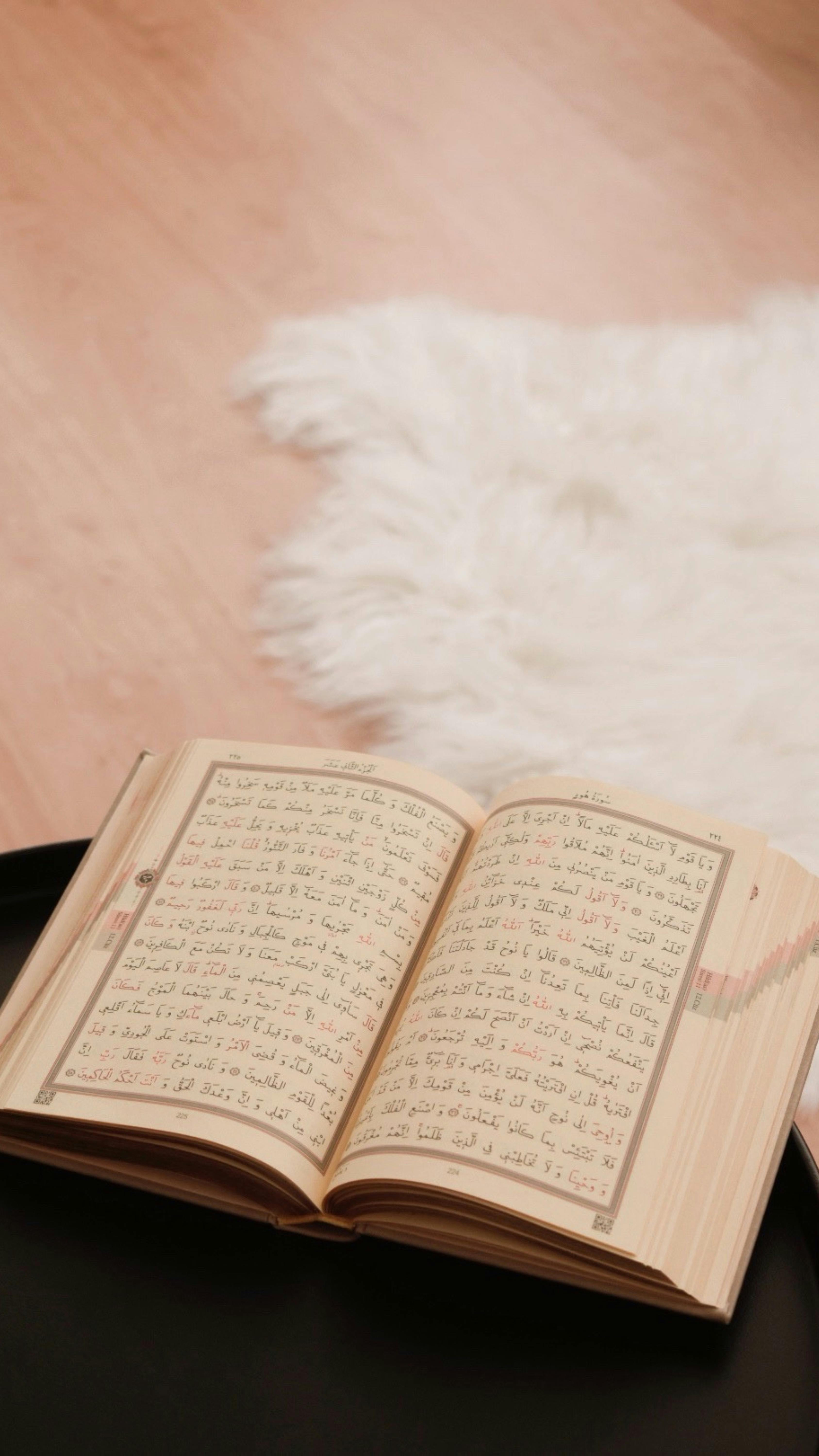 open arabic book on table with cozy rug