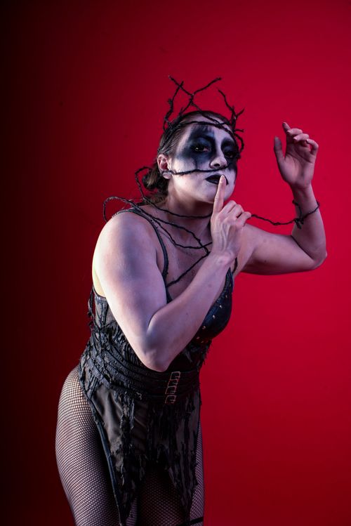 Free Striking theatrical portrait featuring gothic makeup and costume against a vivid red backdrop. Stock Photo