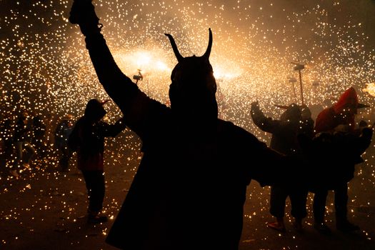 People in costume celebrate with fireworks at a night festival in Les Borges Blanques.