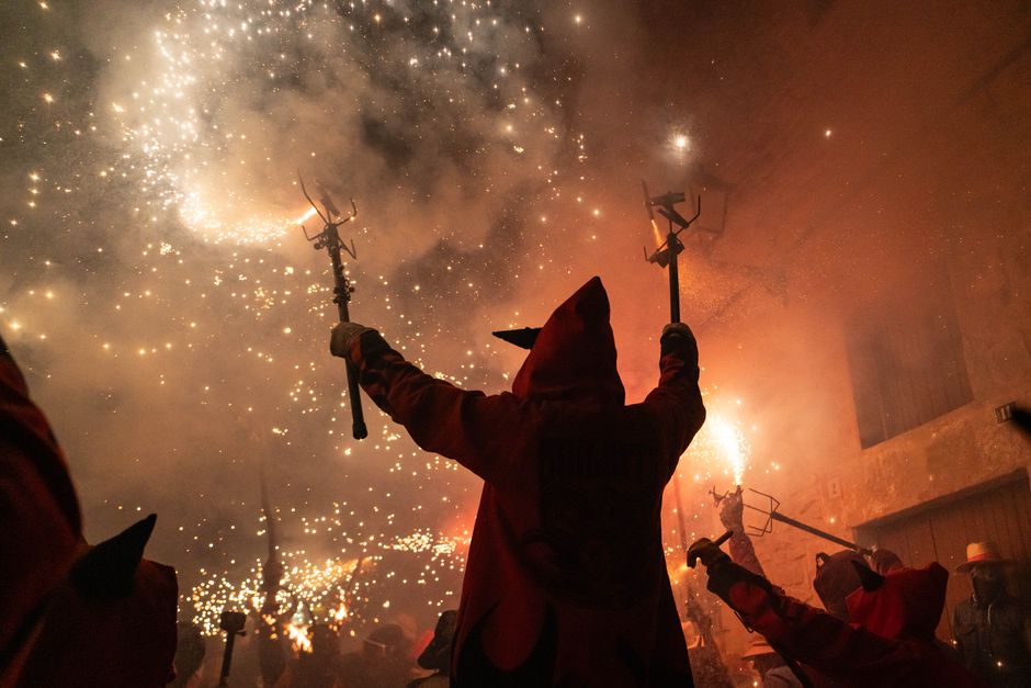 Vibrant festival scene of devils dancing with fireworks in Cataluña, Spain.