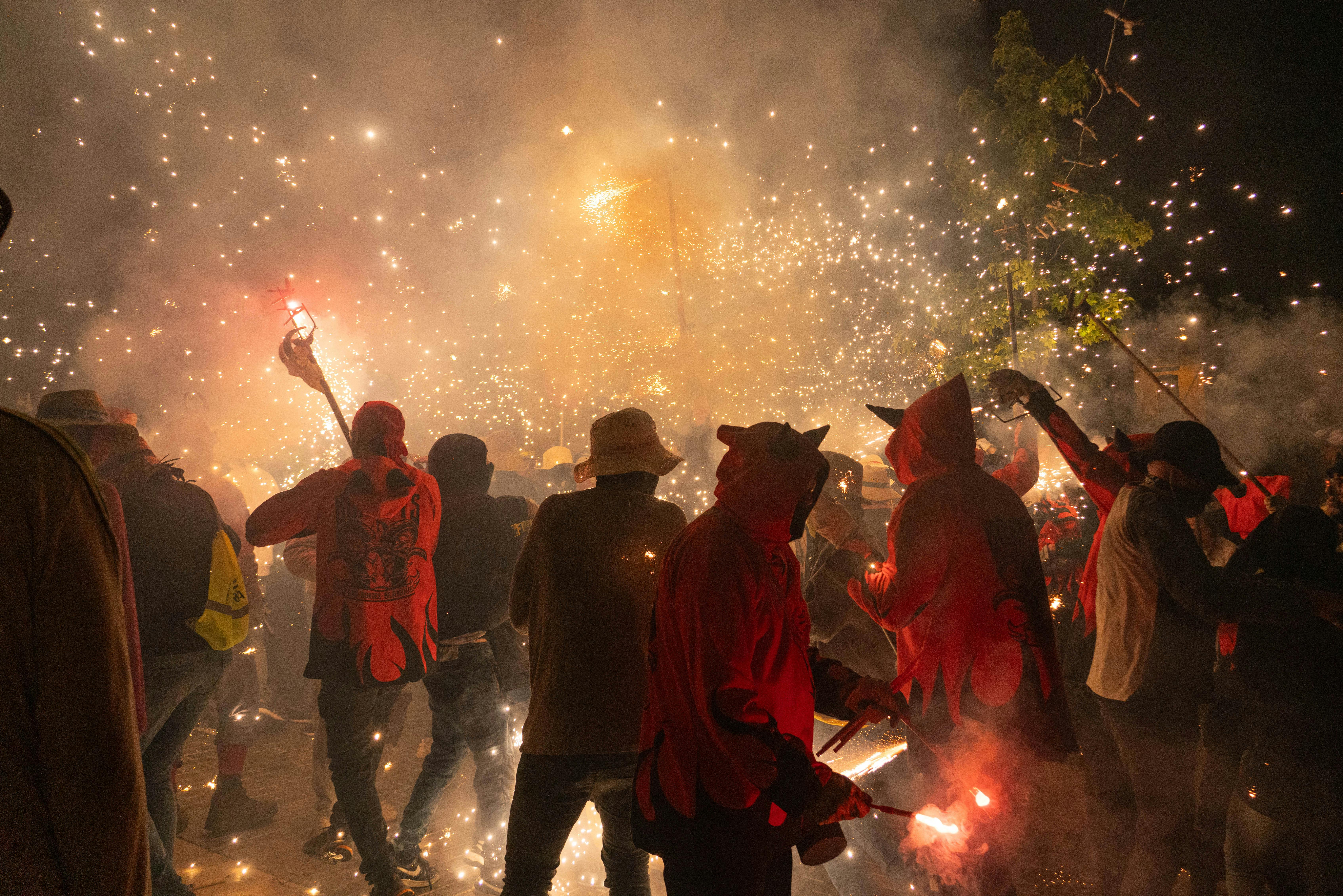Vibrant night festival in Les Borges Blanques, Spain, featuring traditional costumes, fire, and sparklers.