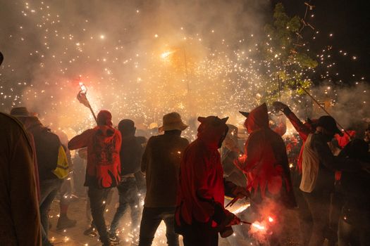Vibrant night festival in Les Borges Blanques, Spain, featuring traditional costumes, fire, and sparklers.