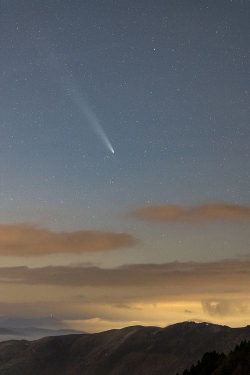 Free A breathtaking night sky in Fregona, Italy, featuring a bright comet over the hills. Stock Photo