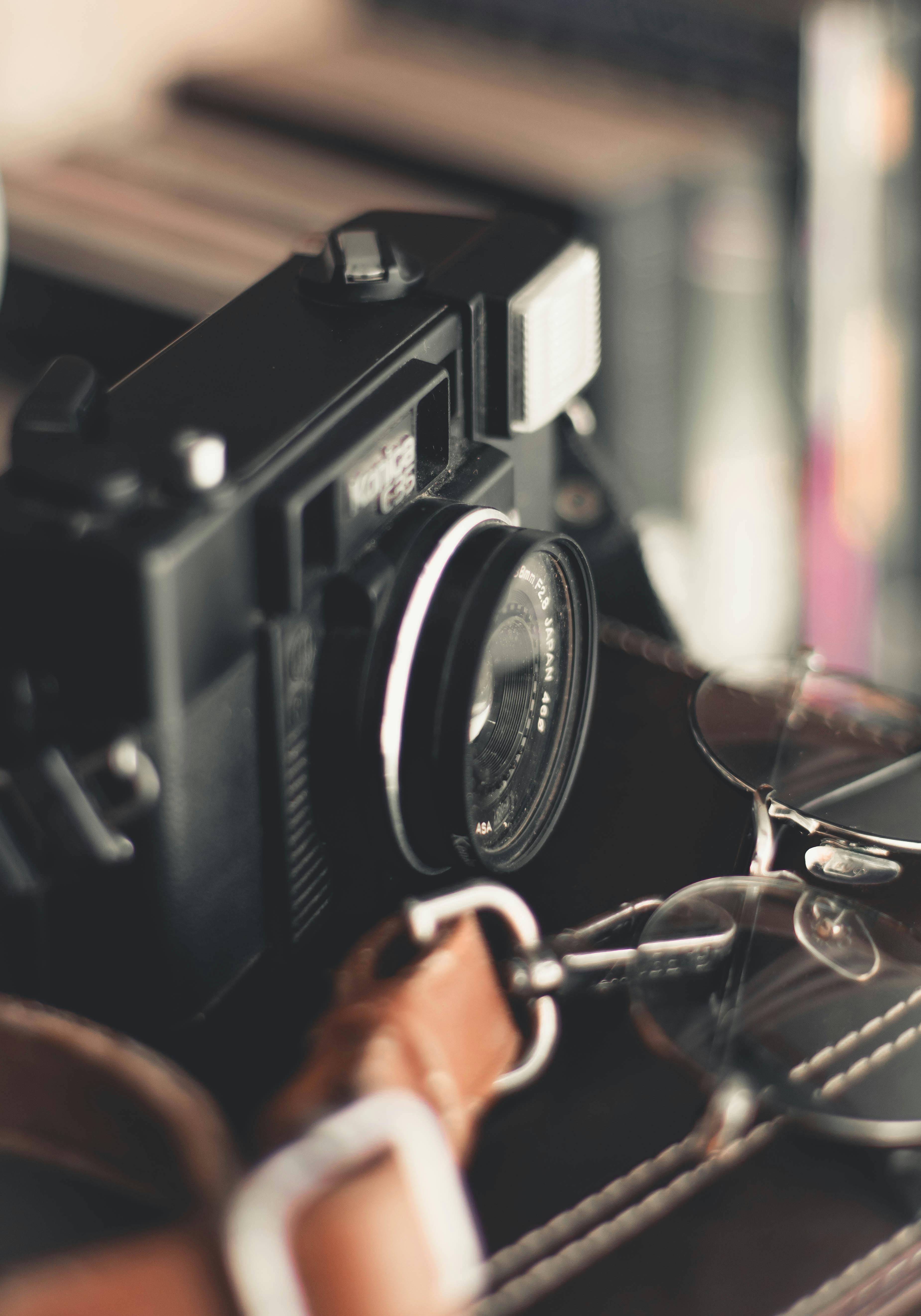 皮包上复古相机的特写，眼镜点缀其间，唤起怀旧之情