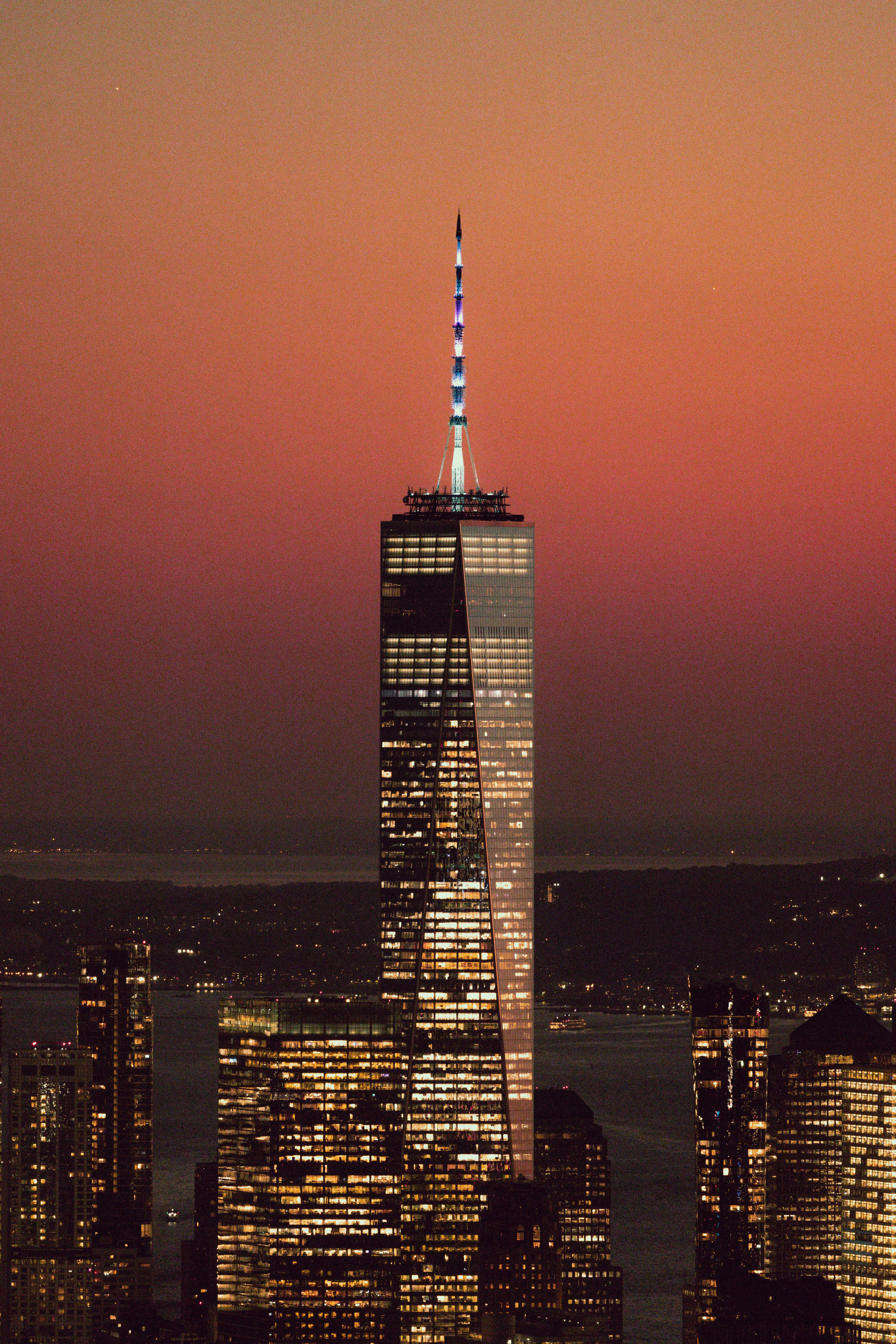 Stunning view of One World Trade Center silhouetted against a vibrant sunset.