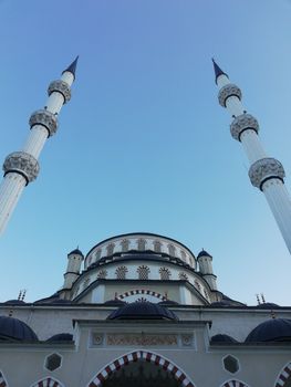 A beautifully captured mosque with tall minarets reaching into a clear blue sky.
