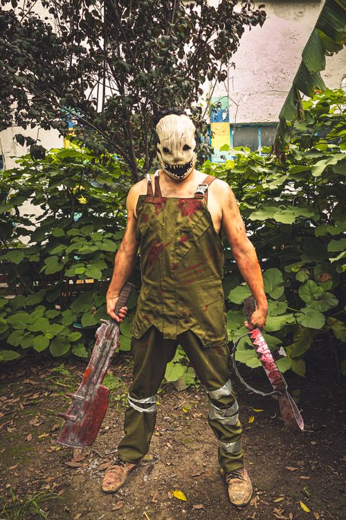 Free Man in horror costume holding bloody weapons, outdoors in Mexico City. Stock Photo