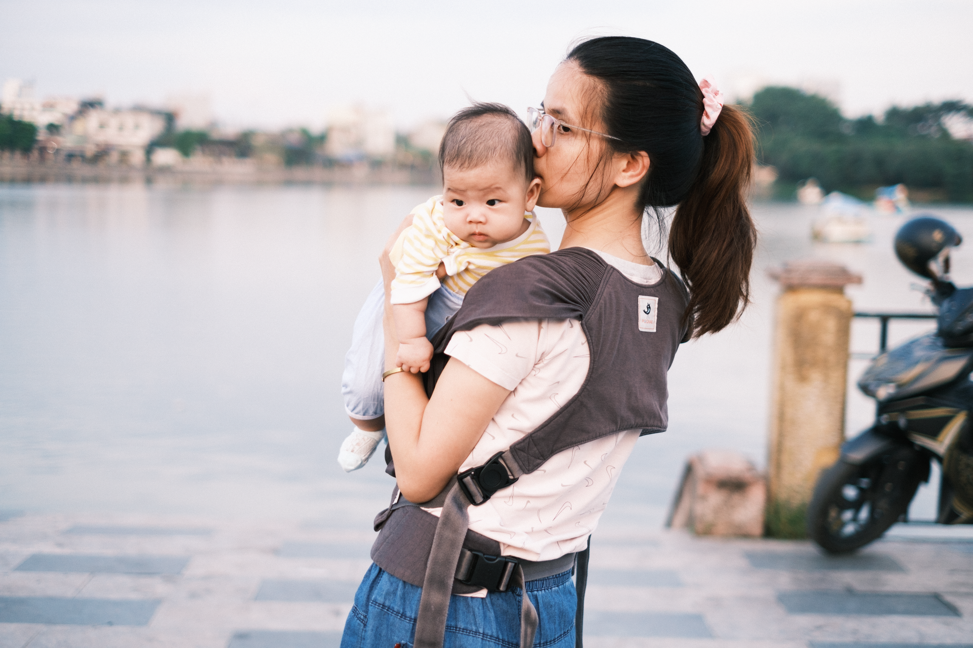 Mother with Baby in Carrier by Scenic Riverside