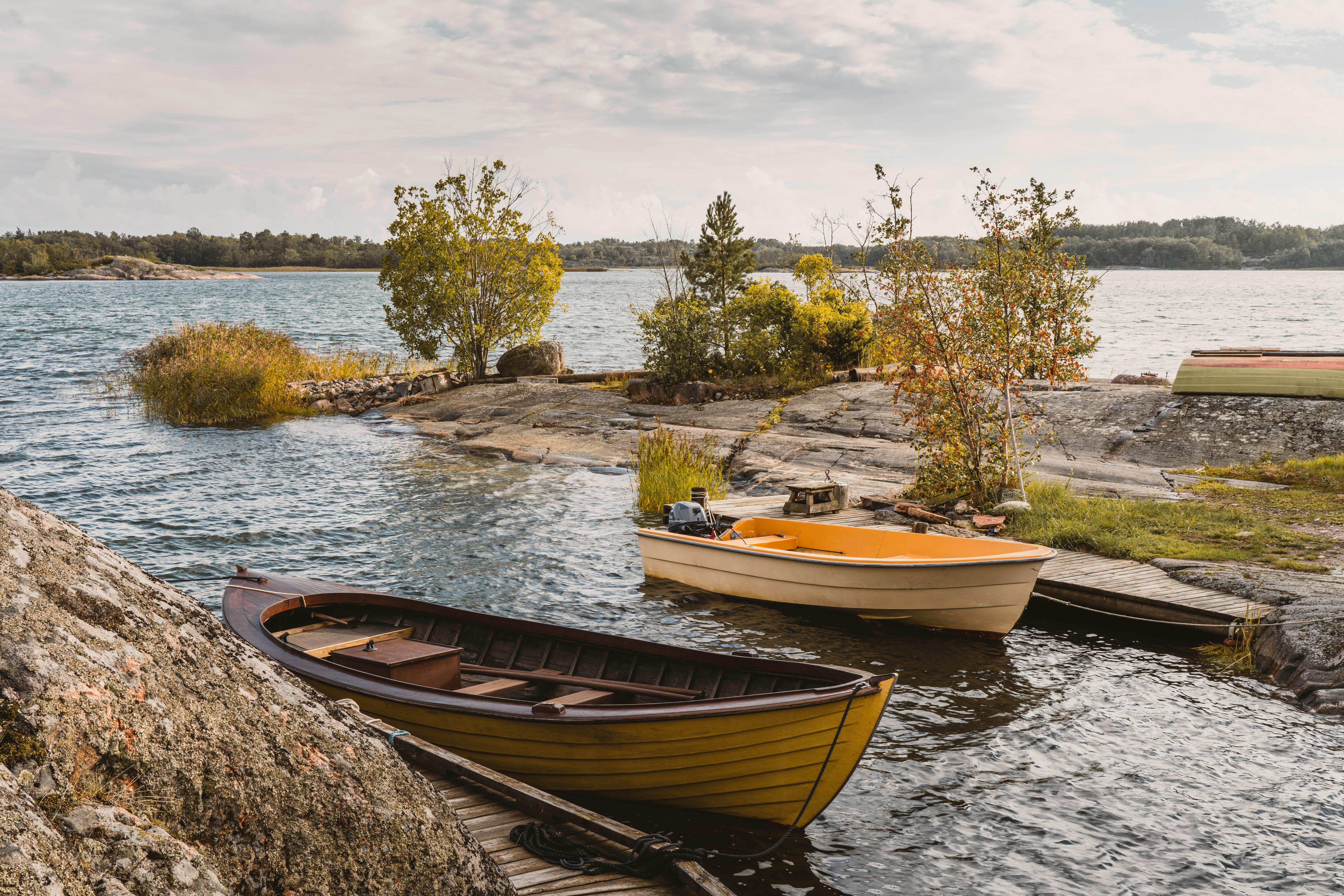Beautiful wooden boats by the rocky shore in the serene Turku Archipelago.